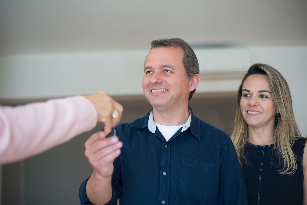 Smiling couple receiving the keys to their new Florida home