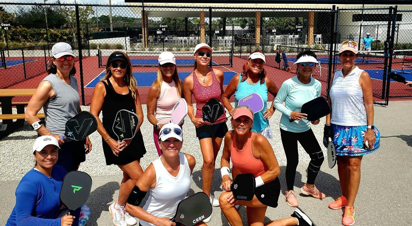 Jill with a group of pickleball friends beside the courts